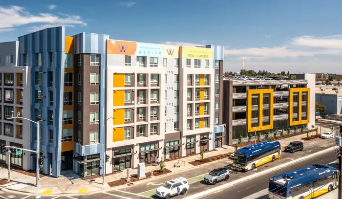 Modern urban apartment complex with vibrant architectural design and convenient street access.