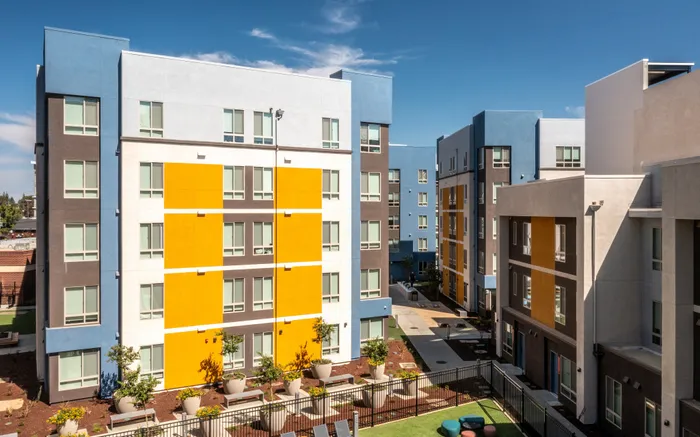 Vibrant modern apartment complex with colorful facades and welcoming green spaces.