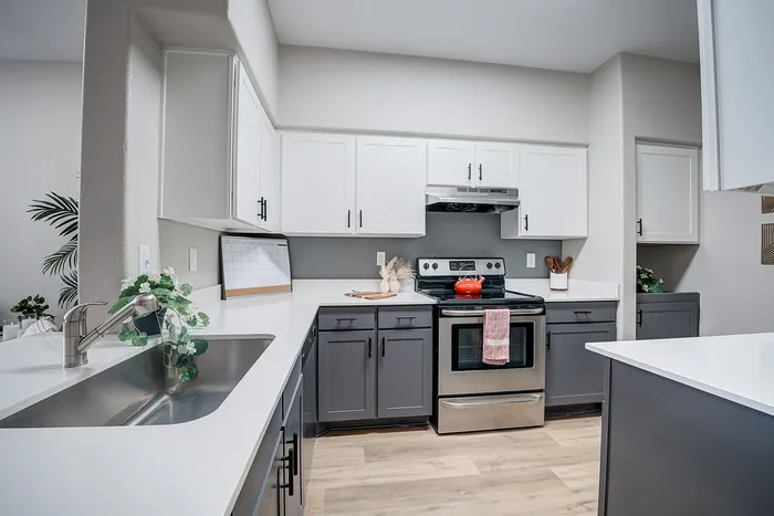 Contemporary kitchen with sleek stainless steel appliances, stylish two-tone cabinets, and elegant countertops, perfect for modern living.