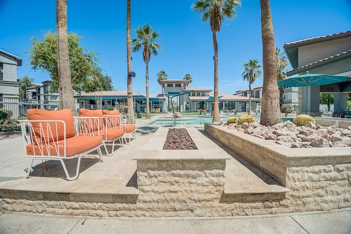 Stunning outdoor area with modern seating, palm trees, and a luxurious pool, offering a resort-style living experience.