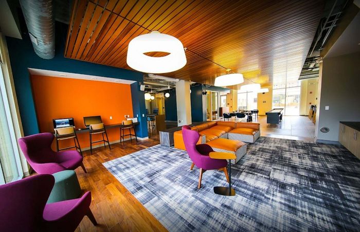 Vibrant and modern lounge area featuring colorful seating, a sleek co-working space, and contemporary lighting.