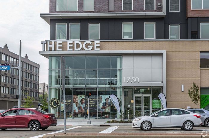 Modern building facade of 'The Edge' with large glass windows and welcoming entrance, located at 1750. Ideal urban lifestyle with nearby amenities and vibrant community setting.