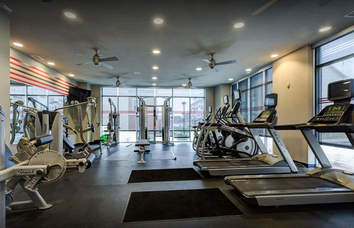 Modern fitness center with state-of-the-art gym equipment, abundant natural light, and a spacious layout.