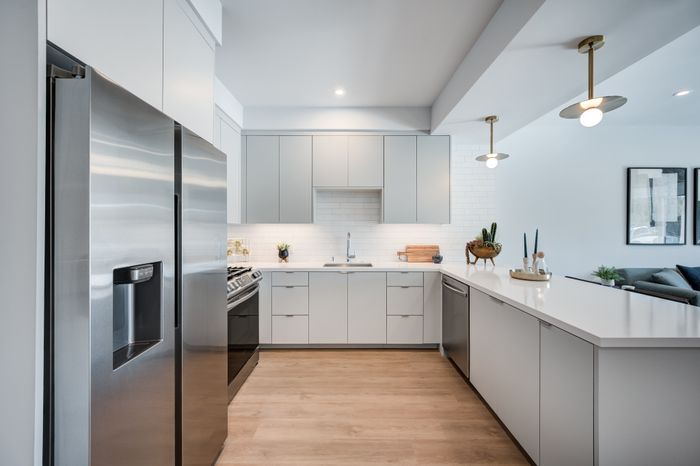 Modern kitchen featuring sleek stainless steel appliances, elegant cabinetry, and a spacious, open layout with stylish pendant lighting.