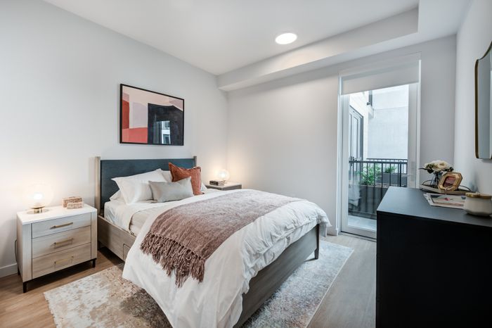 Inviting bedroom with modern decor, plush bed, soft lighting, and private balcony access.