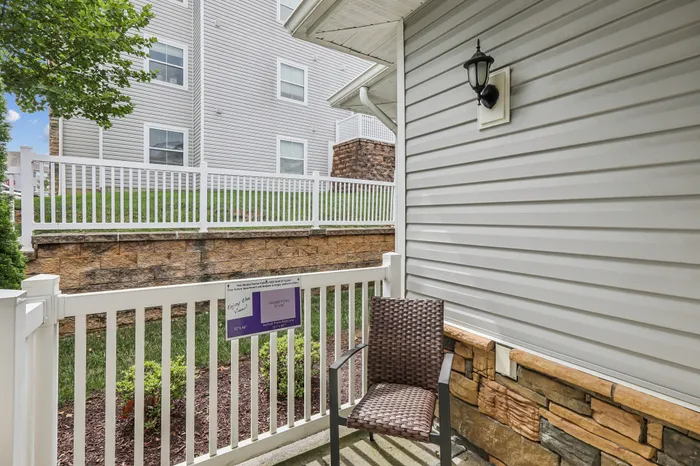 Charming patio with stylish fencing, cozy seating, and classic outdoor lighting, perfect for relaxation.