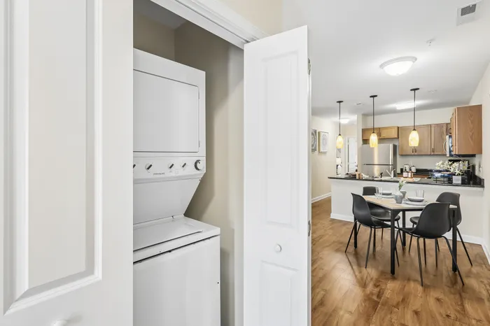 Modern apartment with stylish open kitchen, cozy dining area, and convenient in-unit laundry facilities.