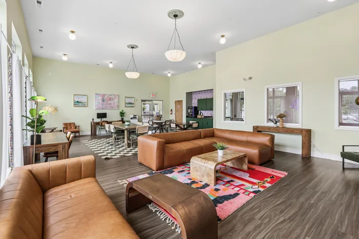 Bright and spacious communal lounge with modern leather sofas, vibrant carpeting, and ample natural light, ideal for relaxation and socializing.