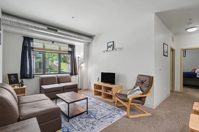 Bright and welcoming living room with modern furniture, large window overlooking a lush garden, and stylish decor.