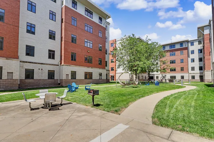 Charming apartment courtyard with modern architecture, lush greenery, outdoor seating, and leisure spaces for relaxation.