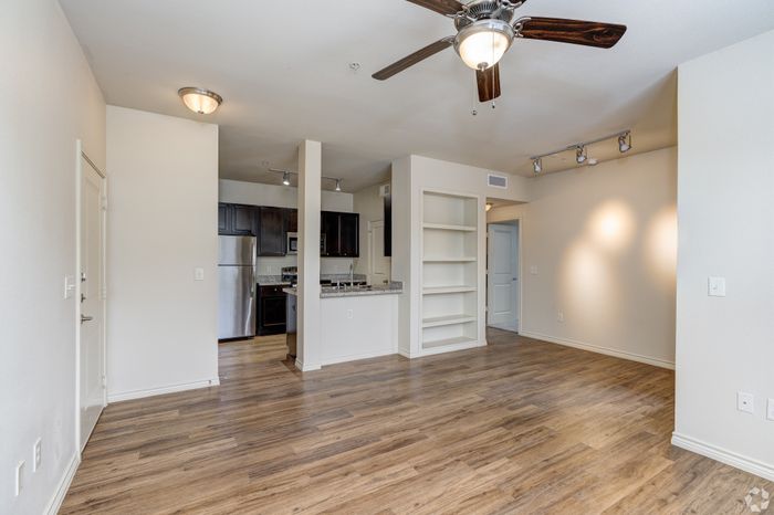 Contemporary open-concept living space with elegant hardwood floors, modern kitchen, and bright natural lighting.