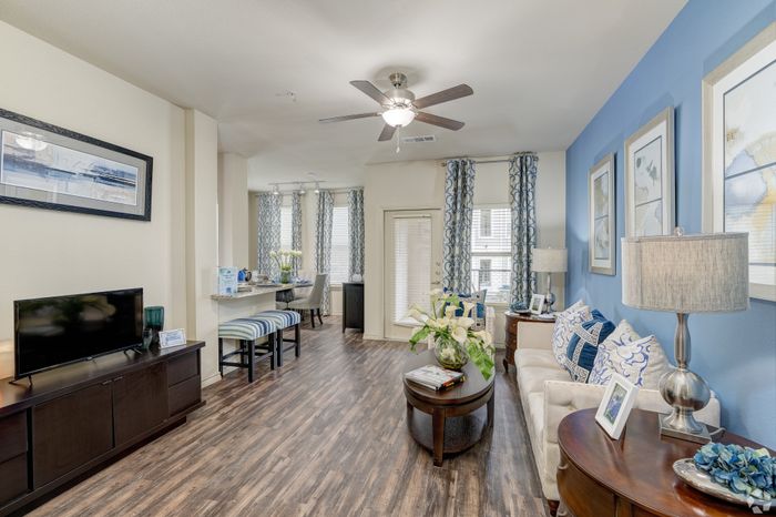 Inviting living room with stylish decor, featuring elegant wooden flooring, a cozy seating area, and vibrant blue accents.