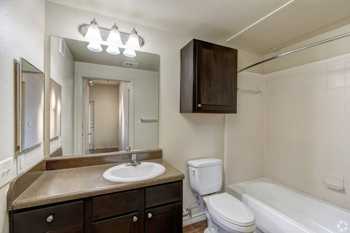 Elegant bathroom showcasing a sleek vanity, modern lighting, and a pristine bathtub for a luxurious touch.