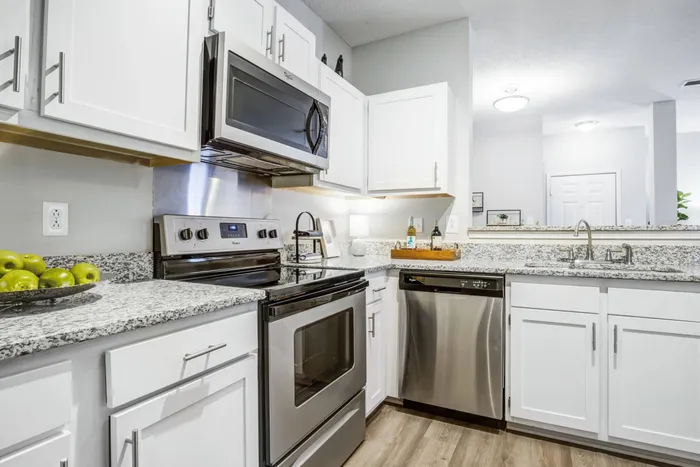 kitchenModel kitchen at our apartments for rent in Mooresville, NC, featuring granite style countertops and white cabinetry.