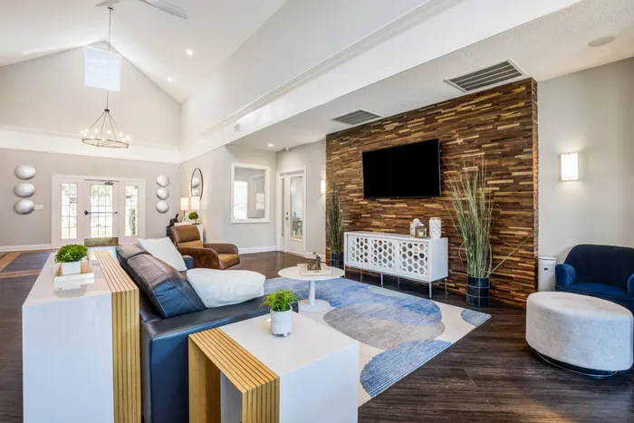 Resident lounge at our apartments for rent in Mooresville, NC, featuring a flat screen TV and wood grain floor paneling.