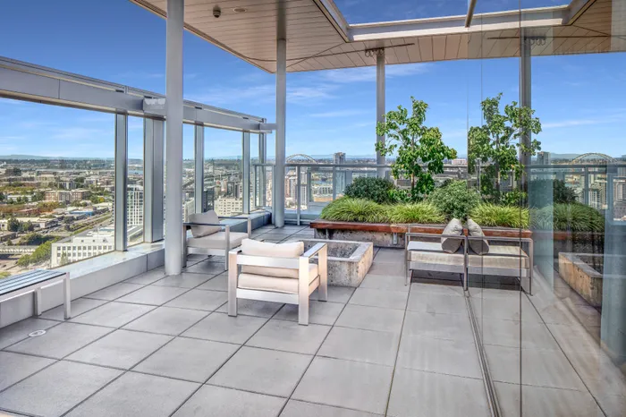Rooftop lounge and common area at our apartments in Portland, OR, featuring chairs, a fire pit, and greenery.