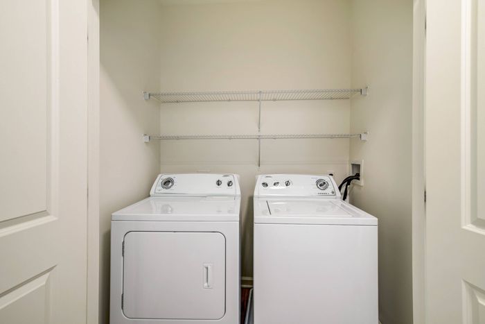 The laundry room at our apartments in Ossining, featuring wood grain floor paneling and in-home washer and dryer.