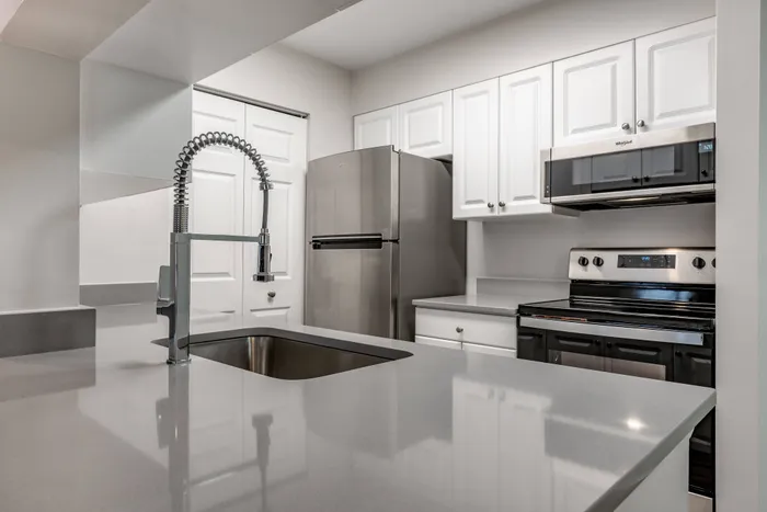 Model kitchen at our apartments for rent in Bowie, MD, featuring grey countertops and white cabinetry.