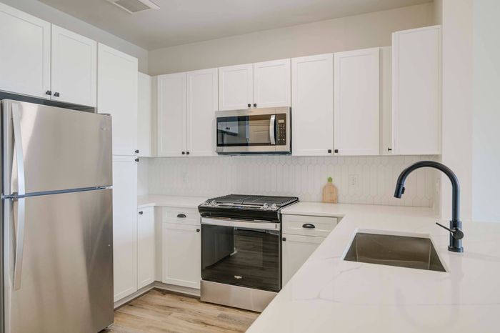 White cabinetry, backsplash, and stainless steel appliances in an Ossining apartment for rent.