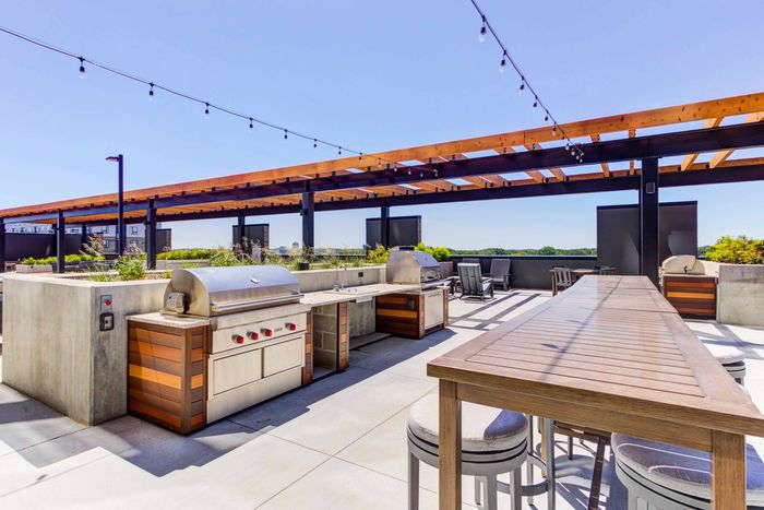 Two outdoor grills with outdoor dining area in front