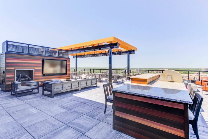 Outdoor TV and fireplace with a seating area in front