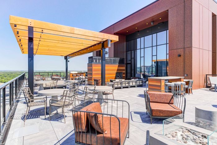 Multiple sets of outdoor tables and chairs on a rooftop
