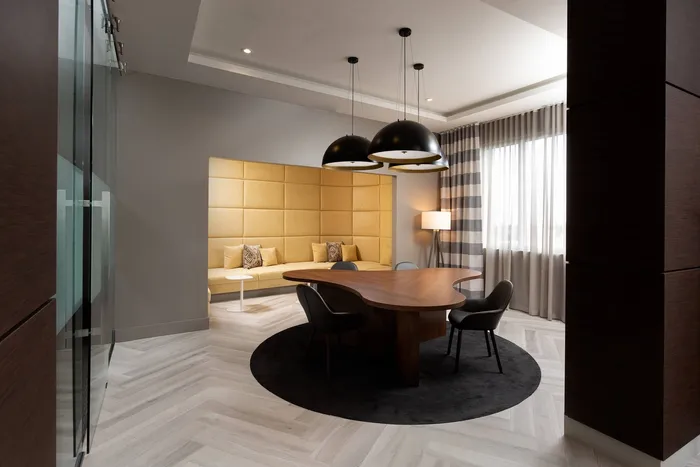 Lounge at our apartments in Fort Lauderdale, featuring a black conference table, yellow booth seating, and elegant decor.