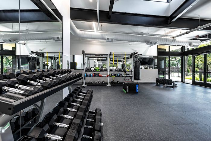 Modern fitness center with cardio and strength-training equipment at Perch Apartments in South Austin.