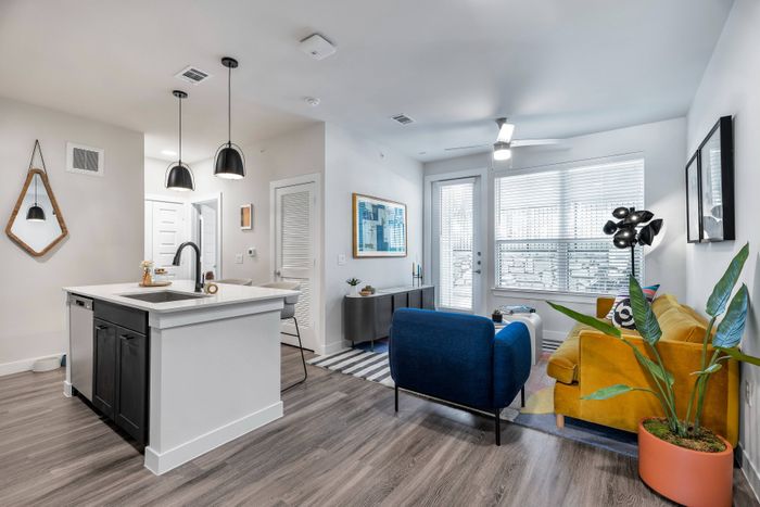 Open-concept apartment living room with large windows at Perch Apartments in Austin.