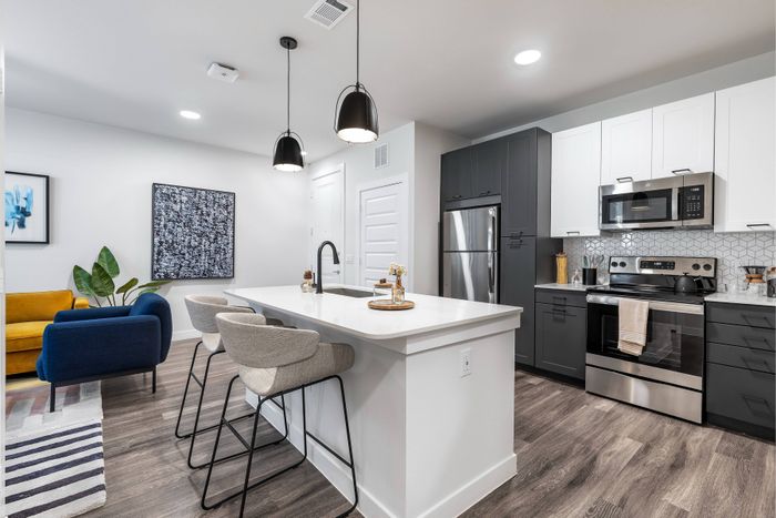 Modern apartment kitchen with two tone cabinets, countertops and stainless steel appliances at Perch Apartments.