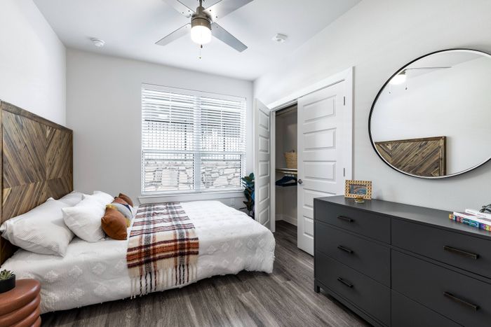Bright apartment bedroom with large windows and modern finishes at Perch Apartments in South Austin, TX.