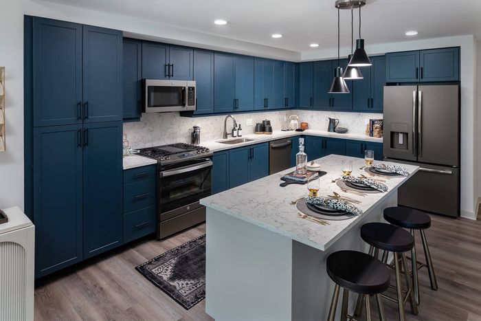 Large Kitchens with stainless steel appliances, prep island, and stylish quartz backsplash