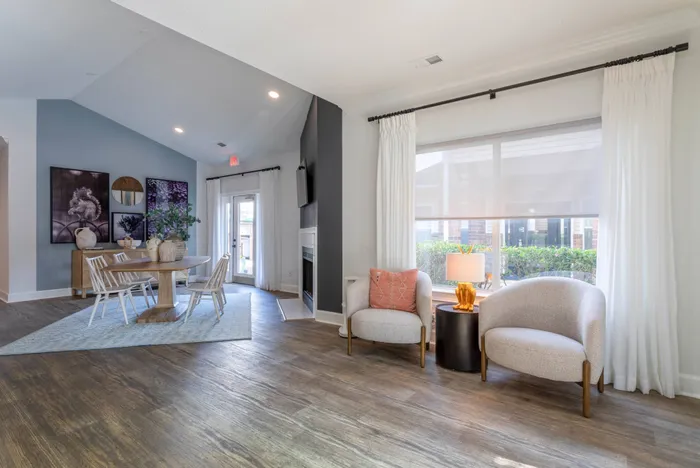 Clubhouse's interior including a fireplace, TV, dining table with four chairs, and two additional chairs for lounging