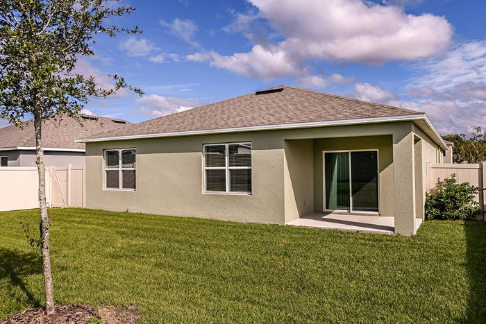 Exterior view of a home for rent with a patio. Beautifully landscaped, fenced in backyard, at a home for rent in Apopka, Florida.