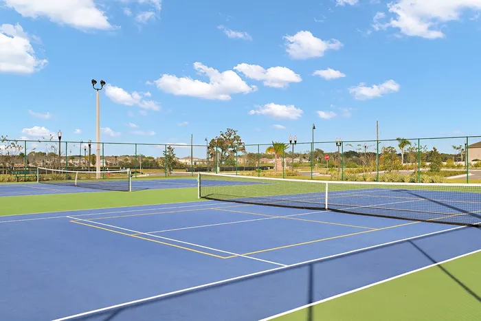 The tennis courts and sports facility near our Apopka townhomes, featuring basketball hoops and surrounding marshes.