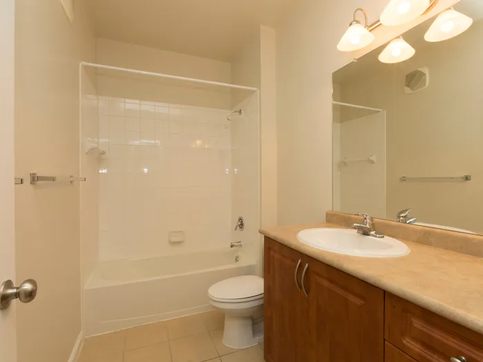 Marlborough MA apartment bathroom with tiled floors and wooden cabinetry.