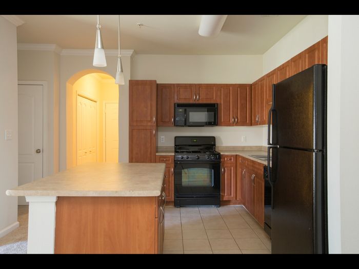 Marlborough MA apartment kitchen with tiled floor and wooden cabinetry.