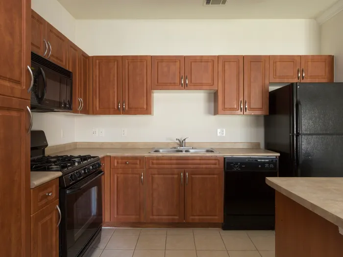 Marlborough MA apartment kitchen with tiled floor and wooden cabinetry.