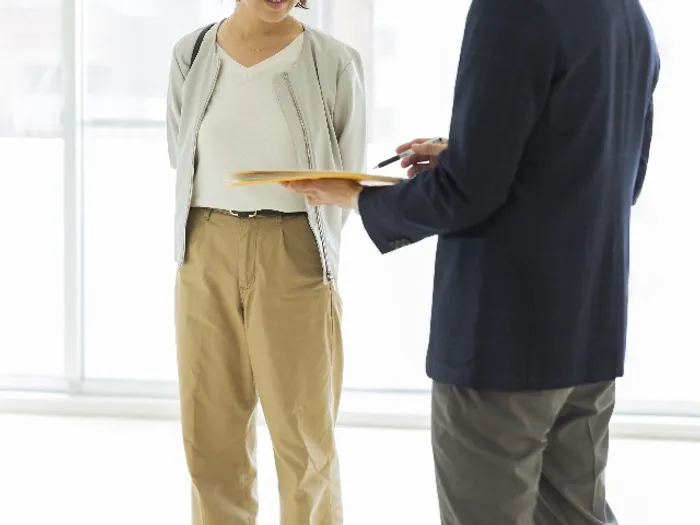 two people talking and pointing to folder