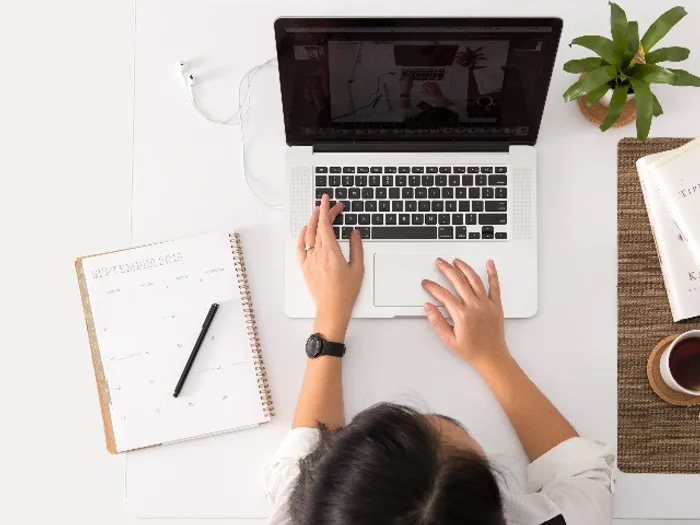 person on laptop with note pad
