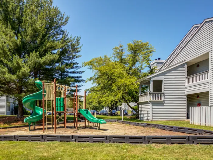 The playground at our apartments for rent in Bowie, MD, featuring a colorful play structure and view of the apartments.