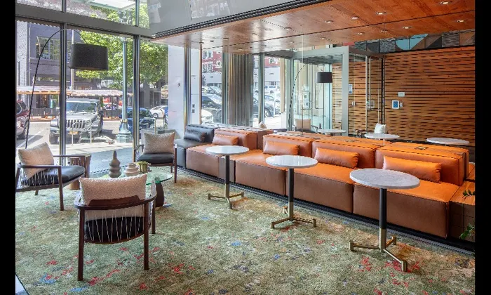 A lobby with seating a floor to ceiling windows inside Indigo Apartments in Portland Oregon.