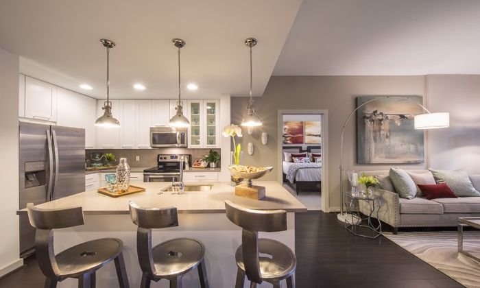 Model kitchen at our apartments for rent in Atlanta, featuring counter seating and a view of the bedroom.