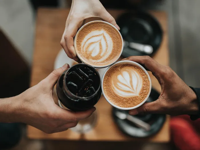 Three coffees being held together at a cafe near our apartments for rent in Owings Mills, MD, as seen from above.