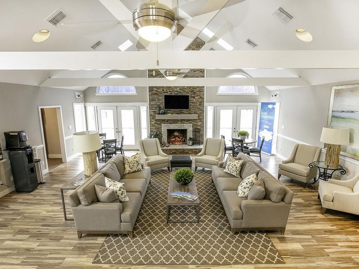 Resident lounge at our apartments for rent in Leesburg, VA, featuring wood grain floor paneling and a fireplace.