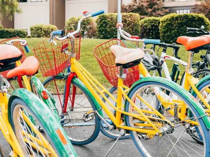 Color bikes lined up on the street near our apartments for rent in Leesburg, VA, featuring cruisers with baskets.