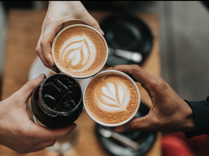 Three coffees being held together at a cafe near our apartments for rent in Leesburg, VA, as seen from above.
