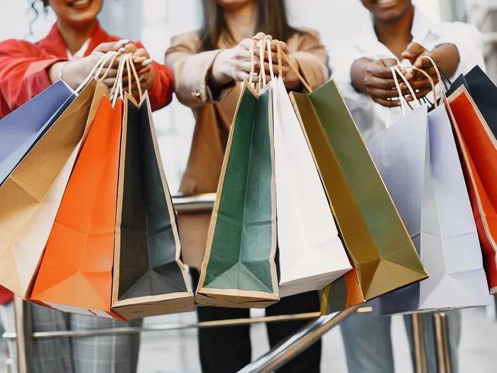 3 women holding out shopping bags