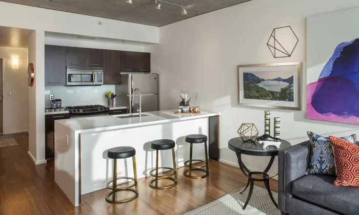 Model kitchen at our apartments in Portland, OR, featuring stainless steel appliances and wood laminate cupboards.