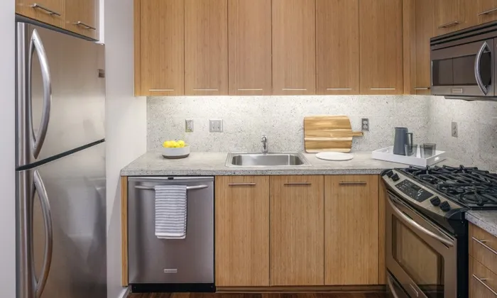 Model kitchen at our apartments in Portland, OR, featuring stainless steel appliances and wood laminate cupboards.
